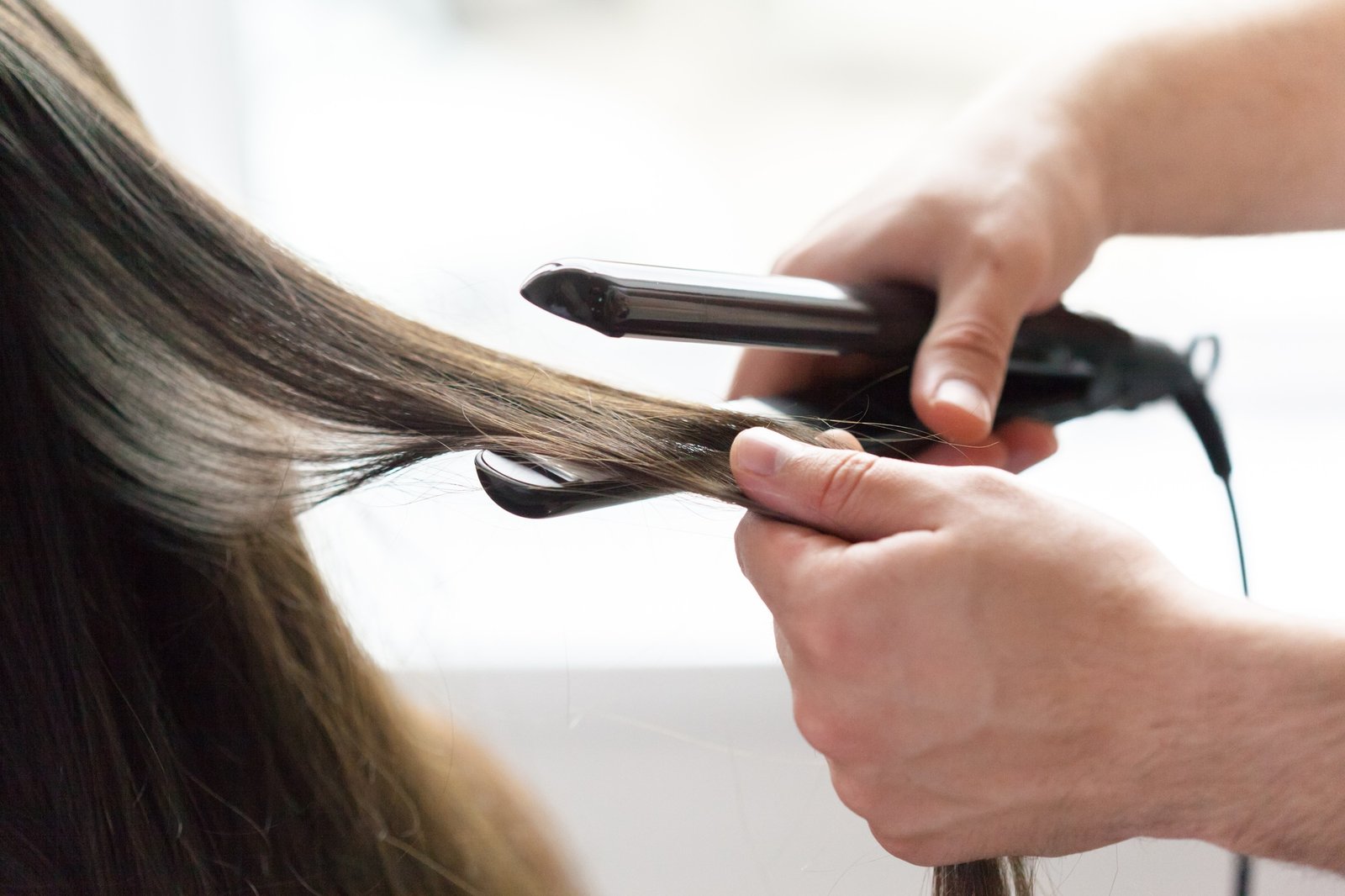 Hairdresser does hair style of woman
